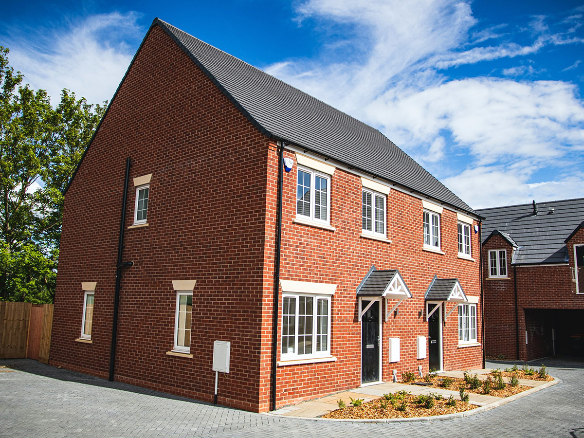 Image of a new build house, red brick and grey tiled roof